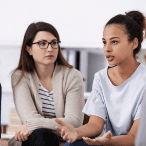 two women talking with a group